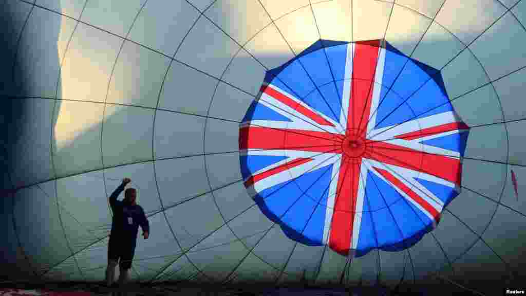 A crew member prepares a partially inflated balloon at the annual Bristol International Balloon Fiesta, near Bristol, Britain.