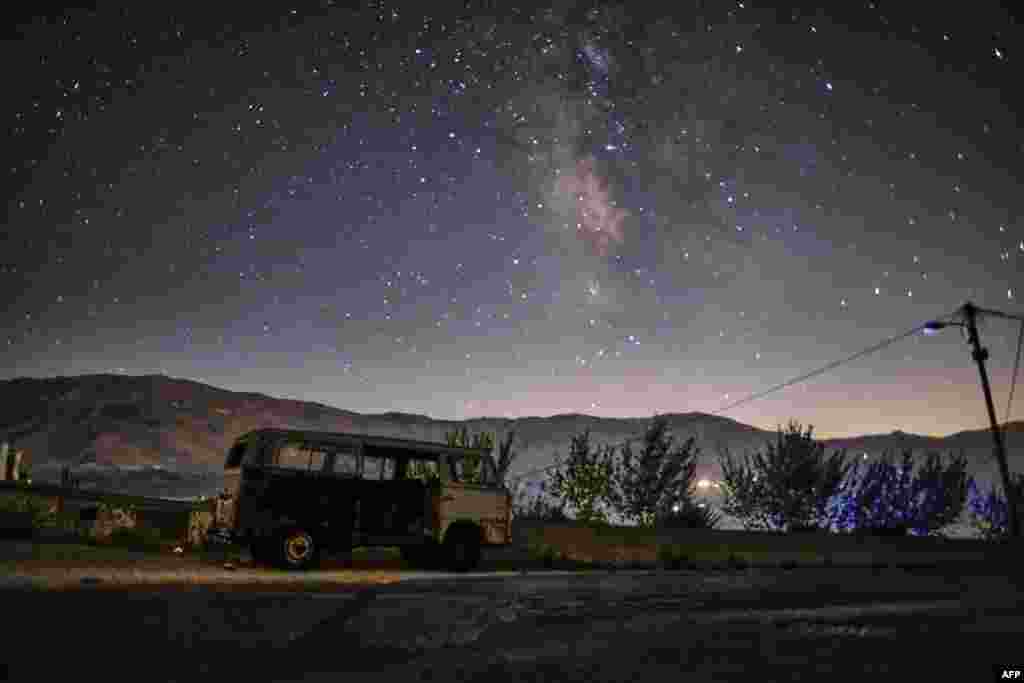 A long exposure picture taken early on Aug. 28, 2022, shows a view of the Milky Way galaxy in the sky above a derelict van in the town of Bcahrre in the mountains of Lebanon, north of the capital Beirut.
