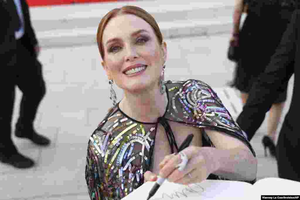 Jury president Julianne Moore signs autographs upon arrival at the premiere of the film 'White Noise' and the opening ceremony during the 79th edition of the Venice Film Festival in Venice, Italy.