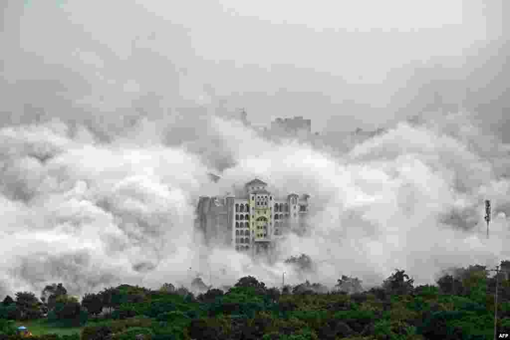 A residential building is engulfed in dust after a controlled implosion demolished the 100-meter-high residential "Twin Towers" in Noida on the outskirts of New Delhi, India. Two illegally built residential high-rises were demolished in a rare crackdown on developers who cut corners and swindle unsuspecting home-buyers. 