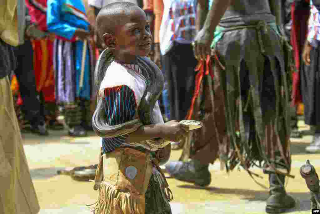 A Sudanese boy carries a snake as demonstrators rally outside the Al-Sadaka hall in the capital Khartoum during a meeting of "The Call of Sudan's People" political initiative.