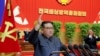 김정은(가운데) 북한 국무위원장이 10일 평양에서 열린 '전국비상방역총화회의' 연단에 나와 오른손을 들어올리고 있다. 