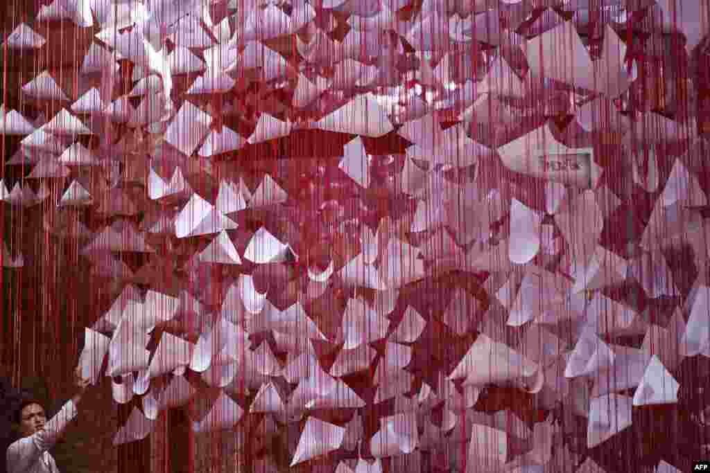 A visitor looks at an art installation called "Tell me your Story" by Japanese artist Chiharu Shiota in Pristina, at the 14th edition of the European Nomadic biennale held in Kosovo.