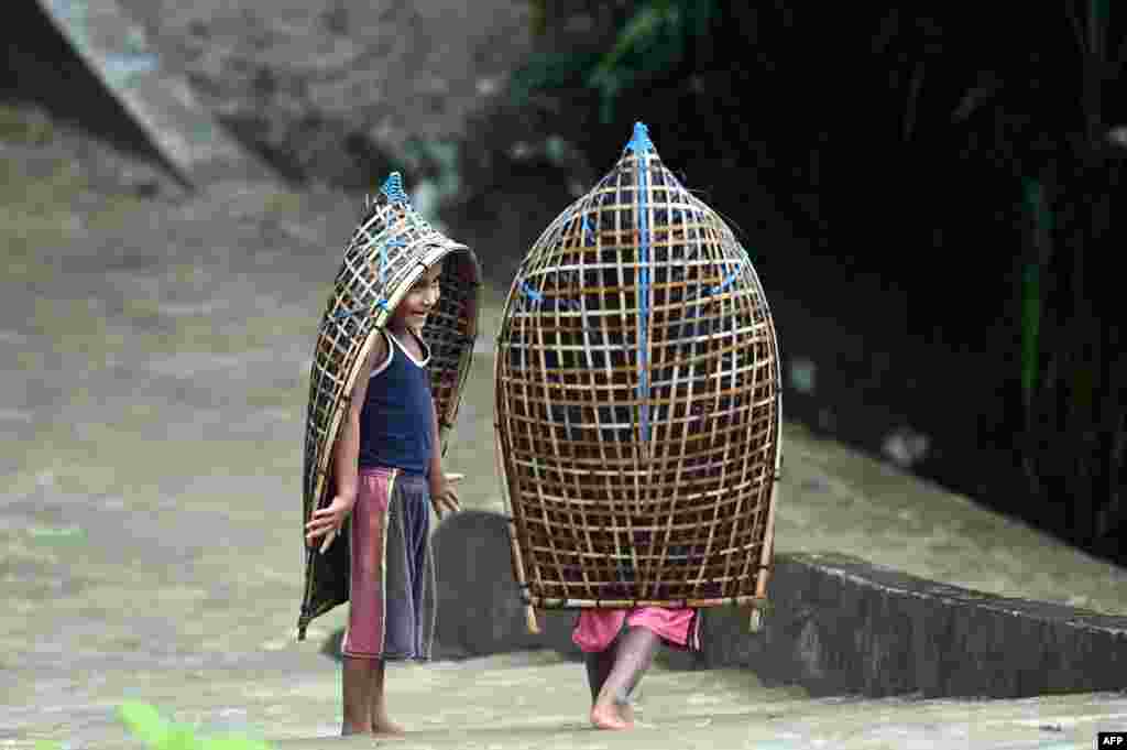 Rohingya refugee children make their way during monsoon rainfall in Kutupalong refugee camp in Ukhia, Bangladesh.