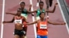Sifan Hassan, of the Netherlands, foreground right, crosses the finish line ahead of Agnes Tirop, of Kenya, left, to win a heat in the women's 5,000-meter run at the 2020 Summer Olympics, July 30, 2021, in Tokyo. 