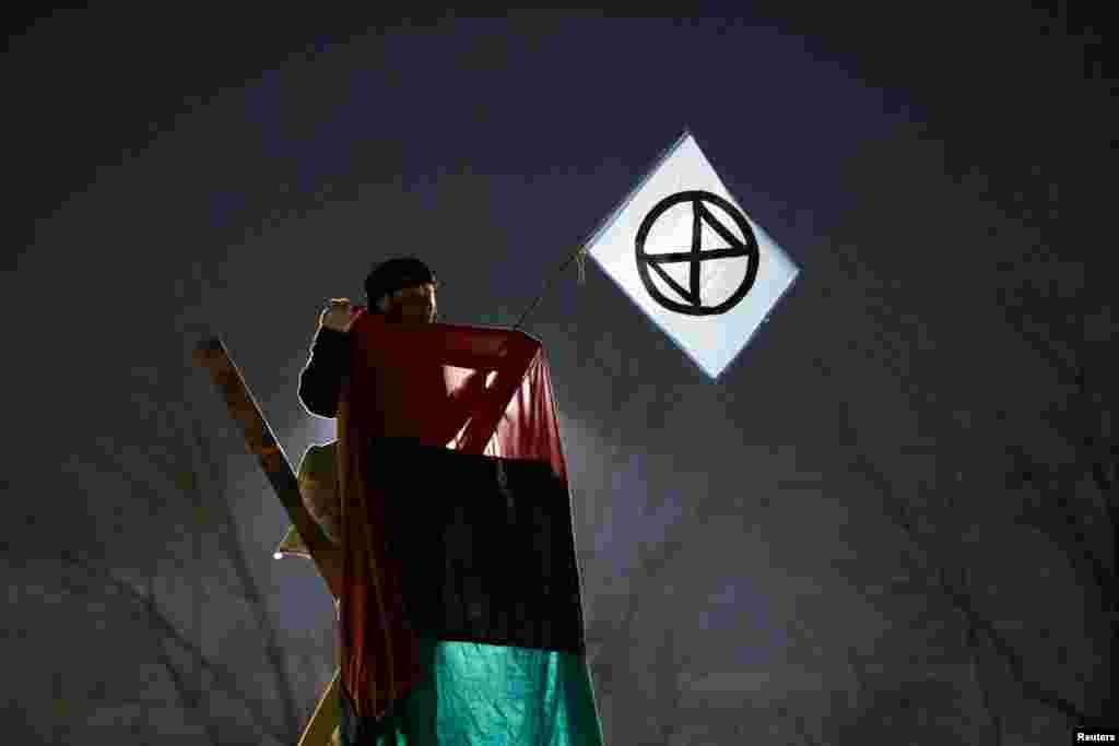 An activist from Extinction Rebellion takes part in an Earth Day demonstration blockading the gate of the New York Times Distribution print facility in Queens, New York City.