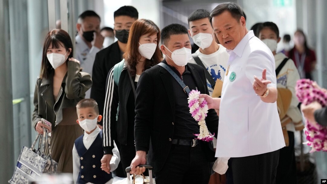 泰國衛生部長阿努廷(右Anutin Charnvirakul)在曼谷的素萬那普國際機場歡迎來自中國的乘客。(2023年1月9日)