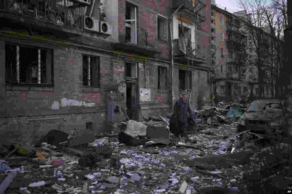 Un residente lleva una maleta con sus pertenencias después de que su edificio resultara gravemente dañado por un bombardeo en Kiev, Ucrania, el viernes 18 de marzo de 2022. Las fuerzas rusas intensificaron su asalto a las ciudades ucranianas el viernes, con nuevos ataques con misiles y bombardeos en los bordes de la capital. Kiev y la ciudad occidental de Lviv, mientras los líderes mundiales presionaban para que se investigaran los repetidos ataques del Kremlin contra objetivos civiles, incluidas escuelas, hospitales y zonas residenciales. 