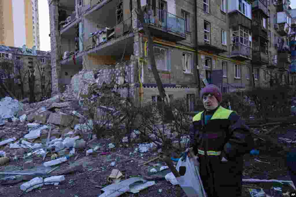 Una mujer camina junto al sitio donde un bombardeo dañó edificios residenciales en Kiev, Ucrania, el viernes 18 de marzo de 2022. Las fuerzas rusas intensificaron su ataque contra las ciudades ucranianas el viernes, con nuevos ataques con misiles y bombardeos en los bordes de la capital, Kiev, y la ciudad occidental de Lviv, mientras los líderes mundiales presionaban para que se investigaran los repetidos ataques del Kremlin contra objetivos civiles, incluidas escuelas, hospitales y zonas residenciales. 