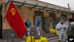 2022年3月17日北京一個封閉社區外，工作人員在聊天。