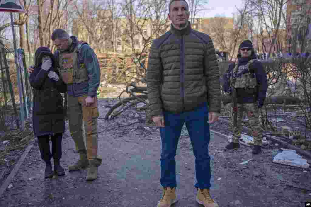 El alcalde de Kiev, Vitali Klitschko, a la izquierda, consuela a un vecino que llora en el lugar donde un bombardeo dañó edificios residenciales en Kiev, Ucrania, el viernes 18 de marzo de 2022. Las fuerzas rusas intensificaron su asalto a las ciudades ucranianas el viernes, con nuevos ataques con misiles y bombardeos. en los límites de la capital Kiev y la ciudad occidental de Lviv, mientras los líderes mundiales presionaban para que se investigaran los repetidos ataques del Kremlin contra objetivos civiles, incluidas escuelas, hospitales y zonas residenciales. 