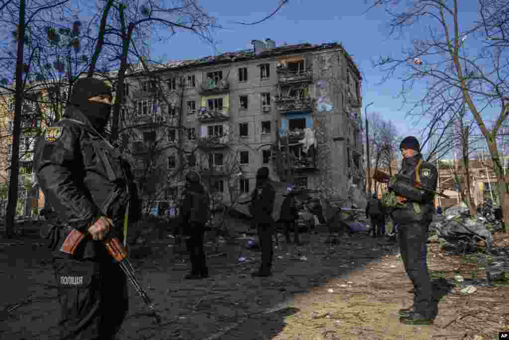 Policías montan guardia en el lugar donde un bombardeo dañó edificios residenciales en Kiev, Ucrania, el viernes 18 de marzo de 2022. Las fuerzas rusas intensificaron su asalto a las ciudades ucranianas el viernes, con nuevos ataques con misiles y bombardeos en los bordes de la capital, Kiev, y el oeste. ciudad de Lviv, mientras los líderes mundiales presionaban para que se investigaran los repetidos ataques del Kremlin contra objetivos civiles, incluidas escuelas, hospitales y zonas residenciales. 
