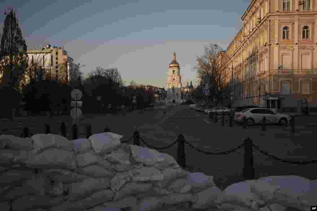 Barricadas en una calle desierta durante el toque de queda en el centro de Kiev, Ucrania, el viernes 18 de marzo de 2022. Las fuerzas rusas intensificaron su asalto a las ciudades ucranianas el viernes, con nuevos ataques con misiles y bombardeos en los bordes de la capital Kiev y la ciudad occidental de Lviv, mientras los líderes mundiales presionaban para que se investigara los repetidos ataques del Kremlin contra objetivos civiles, incluidas escuelas, hospitales y zonas residenciales. 