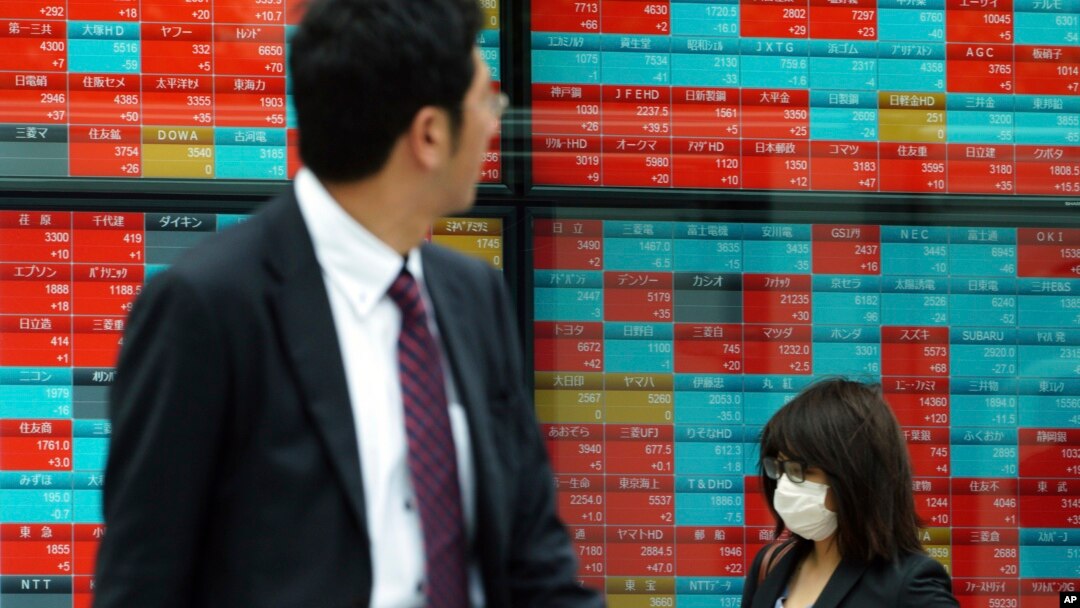 People walk past an electronic stock board showing Japan's Nikkei 225 index at a securities firm in Tokyo, Nov. 7, 2018. Asian shares were mostly higher Wednesday, following the U.S. midterm elections.