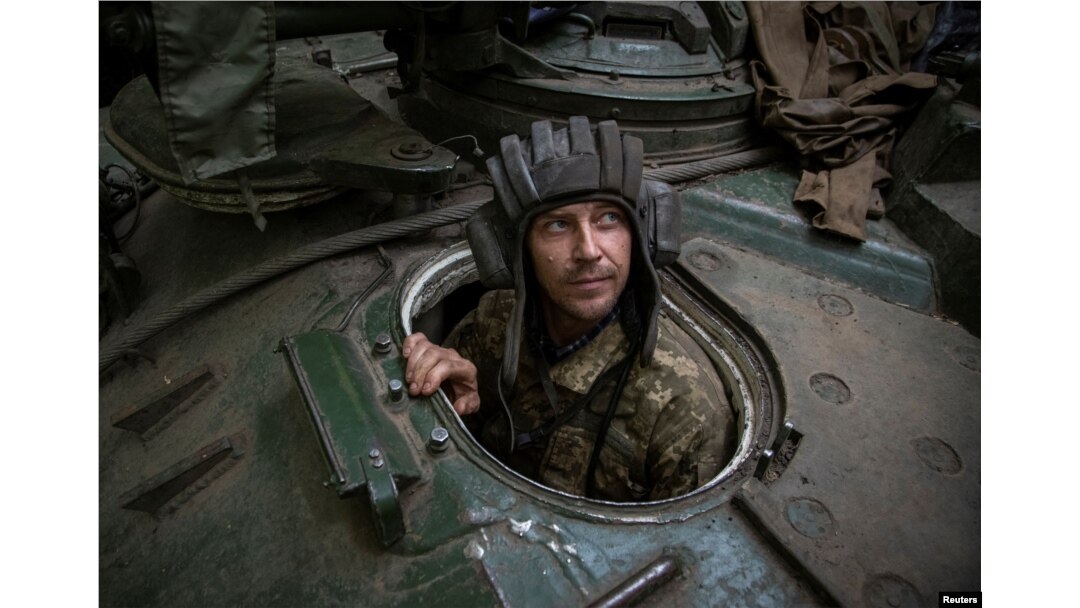 A Ukrainian serviceman looks out of an armoured recovery military vehicle in Donetsk region