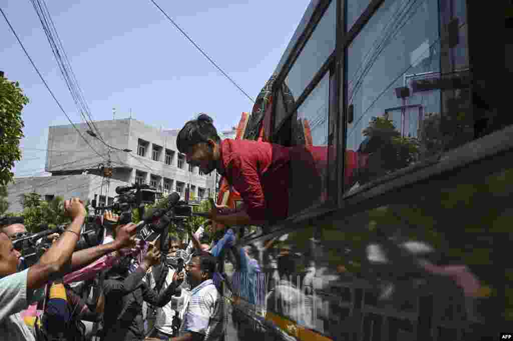 A Bharatiya Janata Party activist speaks to members of the press from a police vehicle after being detained during a protest against West Bengal's state government over alleged irregularities in the School Service Commission recruitment process, iin Kolkata, India.