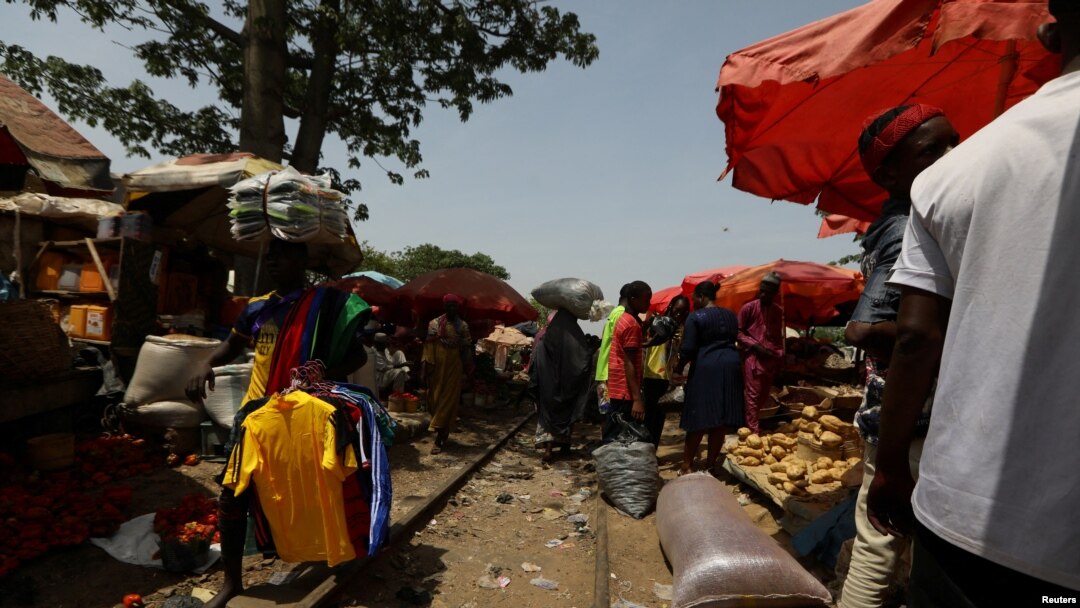 FILE - People trade along a railway line passing through a market in Kaduna, Nigeria, April 30, 2021.