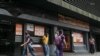 Con una economia nacional en crisis, muchos mecanismos ilícitos se mueven tras bastidores en Venezuela, de acuerdo a un informe de Transparencia Venezuela. Restaurante muestra carteles con precios de productos en dólares estadounidenses, en Caracas, el 22 de abril de 2022.