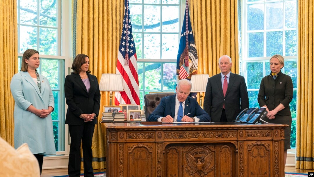 El presidente Joe Biden, acompañado de la vicepresidenta Kamala Harris y tres legisladores más, firma la Ley de Préstamo y Arriendo para la Defensa de la Democracia de Ucrania de 2022 en la Oficina Oval de la Casa Blanca, el 9 de mayo de 2022, en Washington DC.