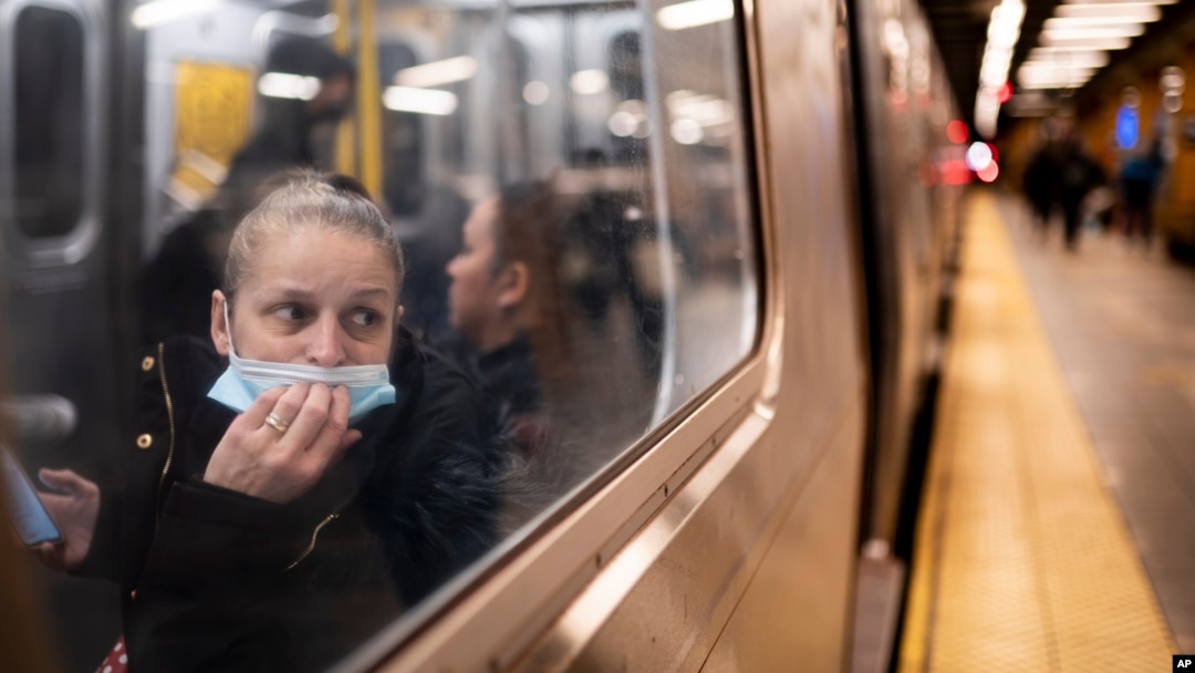 FILE - A passenger looks out onto the platform while riding a northbound train in the 36th Street subway station during the morning commute, in New York, April 13, 2022. 