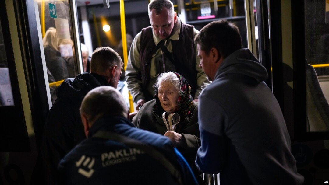Una mujer que huyó de la planta siderúrgica Azovstal en Mariupol recibe ayuda de un autobús a su llegada a un centro de recepción para personas desplazadas en Zaporizhzhia, Ucrania, el 8 de mayo de 2022.