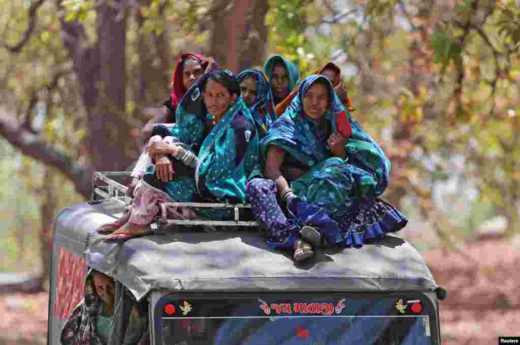 Women sit on top of a vehicle as they leave after casting their votes outside a polling station at Sirohi district in the desert Indian state of Rajasthan, India.