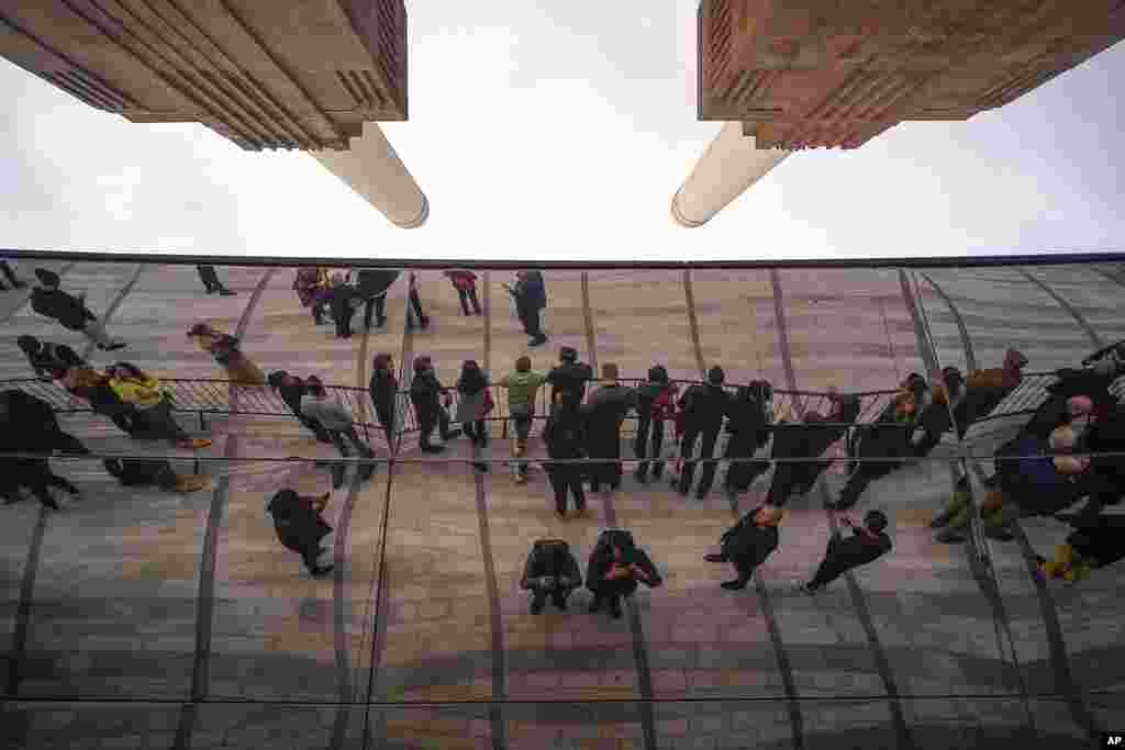 People wait for the opening of the Battersea Power Station, in London. A former power station on the bank of the River Thames that was left derelict for decades is opening after a 9 billion-pound ($10 billion) redevelopment turning the south London site into an attraction complete with shops, bars and apartments. 