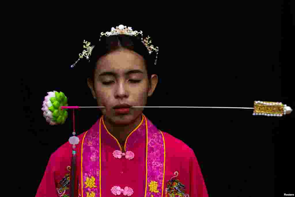 A medium woman with her mouth pierced is portrayed while in trance during the Jui Tui Shrine procession amidst celebrations of the annual vegetarian festival, observed by Taoist devotees from the Thai-Chinese community in the ninth lunar month of the Chinese calendar, in Phuket Town, Thailand, in this photo taken Oct. 2, 2022, and released Oct. 4, 2022.