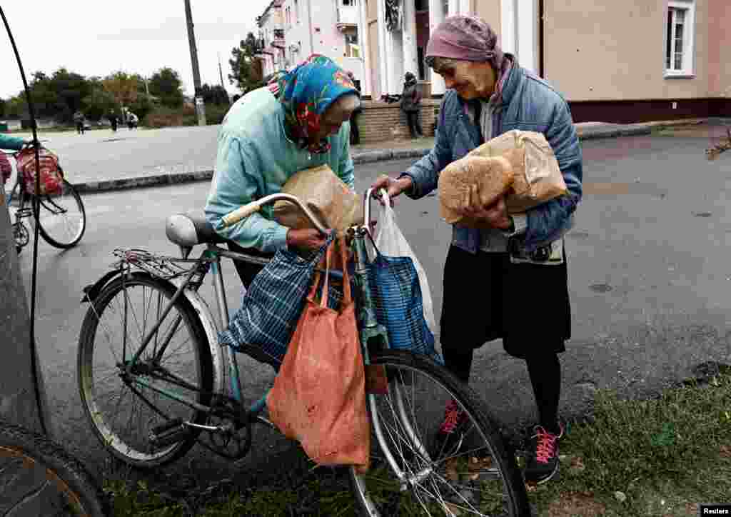 Raisa, 67, and her relative receive humanitarian aid in the recently liberated town of Izium, in Kharkiv region, Ukraine.