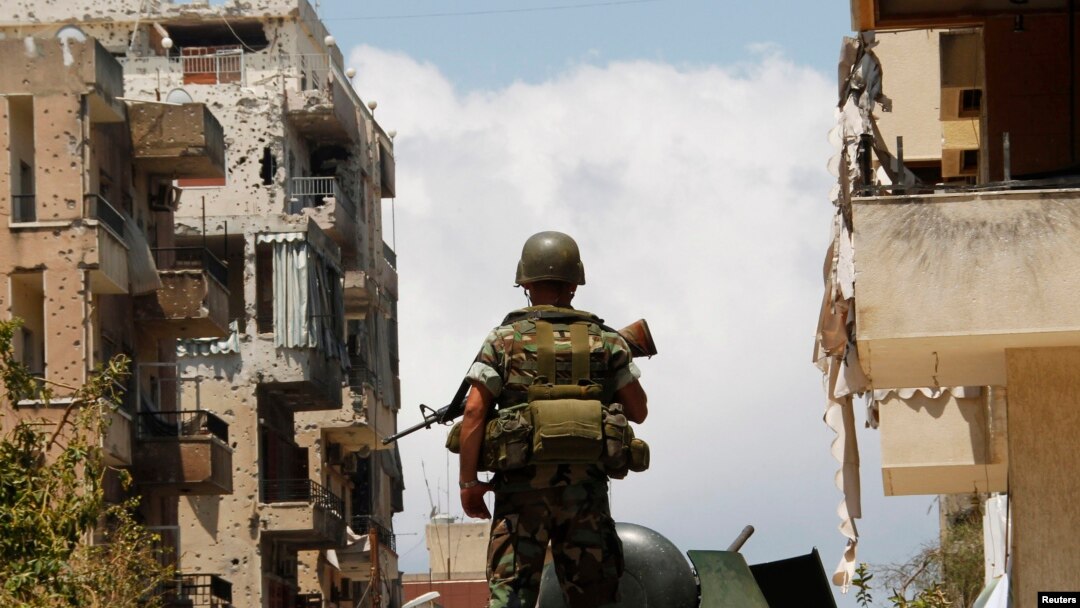 A Lebanese army soldier stands atop of an armored personnel carrier (APC) patrolling the area near a mosque complex where hardline Sunni cleric Sheikh Ahmed al-Assir was believed to be sheltering with his supporters, in Abra near Sidon, southern Lebanon, 