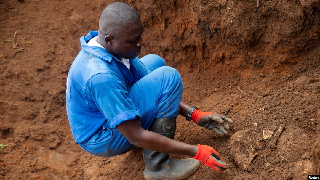 Mfanyakazi wa Burundi kutoka katika Kamisheni ya Ukweli na Suluhu akitoa fuvu la mtu aliyekuwa hajatambulikana kutoka katika kaburi la watu waliozikwa pamoja nchini humo. REUTERS/Evrard Ngendakumana - RC21PE9DJA9D
