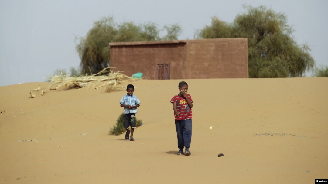 Boys walk on desert sands in the town of Moghtar-Lajjar in west Africa's Sahel region, where the United Nations says civil unrest and a drought have put 18 million people in food insecurity, May 25 2012.