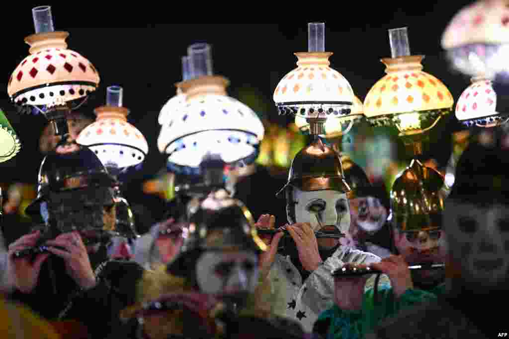 Revelers parade with lanterns during the traditional "Morgenstreich" procession starting the carnival of Basel, Switzerland.
