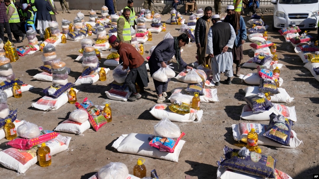 FILE - Afghan workers prepare food supplies during a humanitarian aid campaign for poor families, in Kabul, Afghanistan, Feb. 16, 2022. 