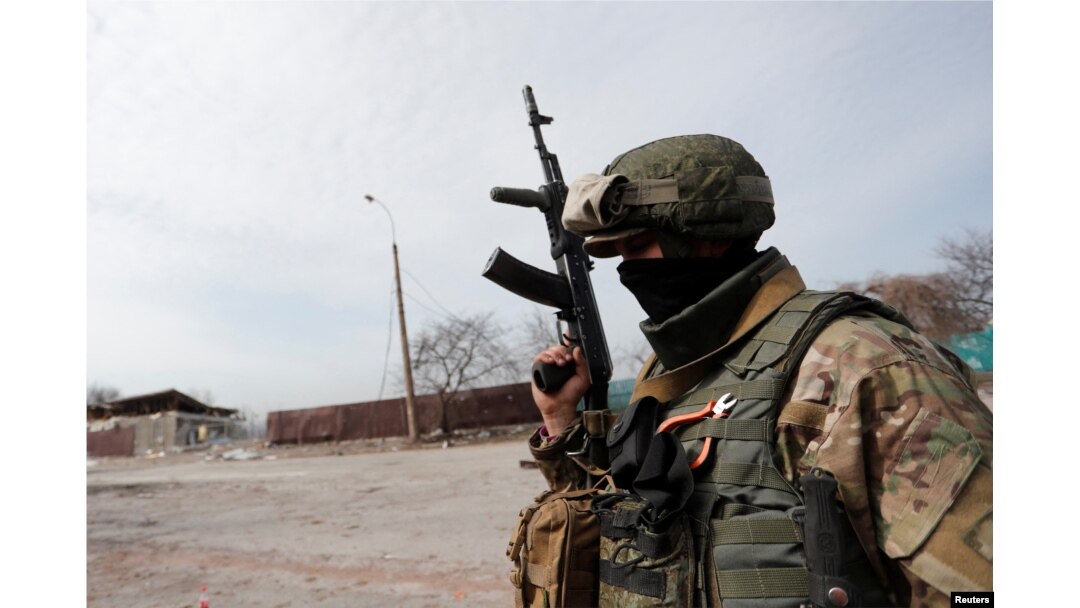 A service member of pro-Russian troops stands in a street during Ukraine-Russia conflict in the besieged southern port city of Mariupol, Ukraine, March 31, 2022.