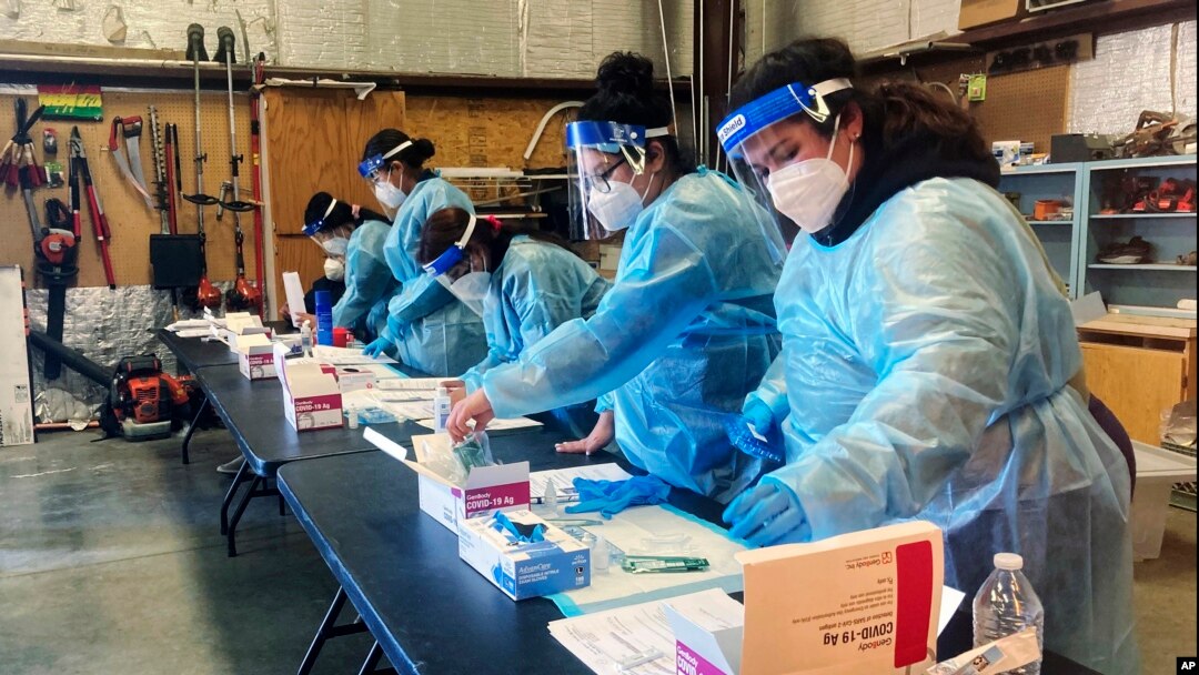 Trabajadoras se toman un descanso después de realizar pruebas diagnósticas de COVID-19 a migrantes que fueron liberados por la Patrulla Fronteriza en el Centro Regional para la Salud Binacional, el 5 de febrero de 2022, en Somerton, Arizona, EE. UU.