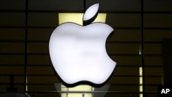 FILE - The Apple logo is illuminated at a store in Munich, Germany, Dec. 16, 2020.