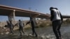 Migrantes cruzan el río Grande hacia la frontera entre México y Estados Unidos, el lunes 19 de diciembre de 2022, en Ciudad Juárez, México. 