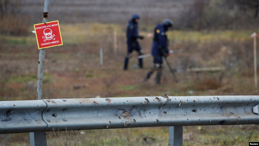 Expertos ucranianos buscan artefactos explosivos sin detonar y minas terrestres junto a la carretera principal a Jersón, Ucrania, el 16 de noviembre de 2022.