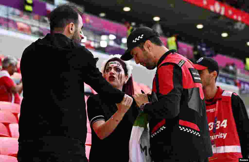 Police officers confiscate an Iranfan's 'Women Life Freedom' Iran flag before the Group B soccer match between Wales and Iran at the Ahmad Bin Ali Stadium in Al Rayyan, Qatar, Nov. 25, 2022.