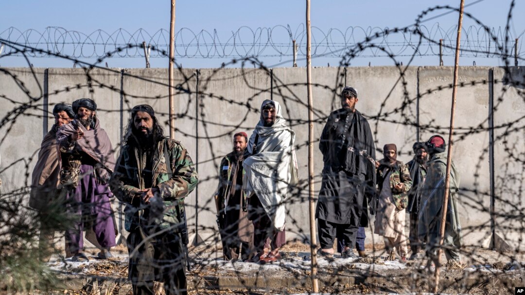 Taliban fighters check the site of an explosion, near the Interior Ministry, in Kabul, Afghanistan, Jan. 1, 2023. 