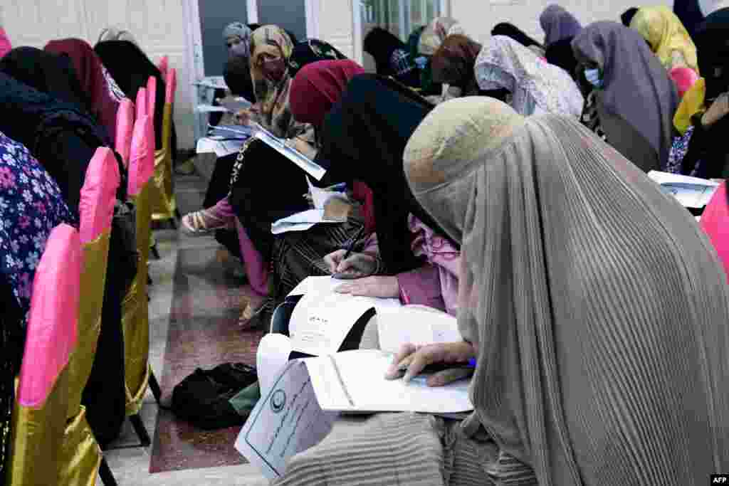 Afghan burqa-clad women take an entrance test at Mamon Tahiri institute in Kandahar, Afghanistan.