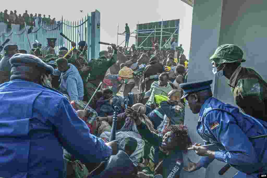 A woman (C) pleads for help as Kenyan security forces intervene during a stampede at the entrance of the Moi International Sports Center in Nairobi, Kenya, ahead of the inauguration ceremony for William Ruto.