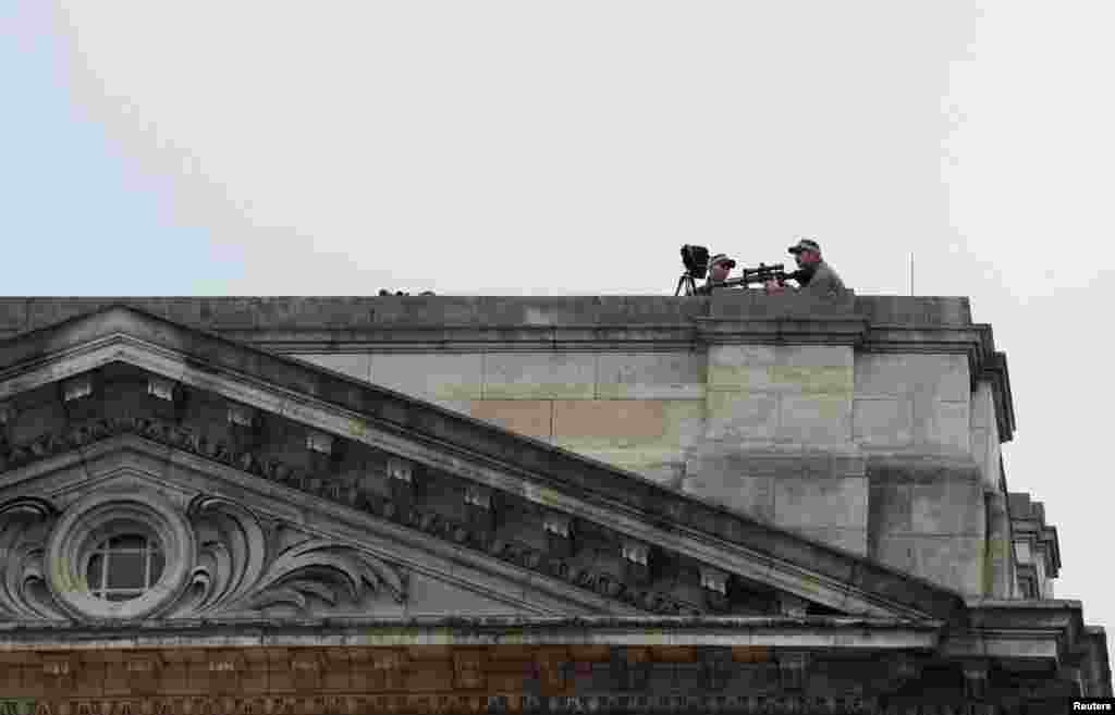 Security personnel stand guard on the terrace of Buckingham Palace in London.