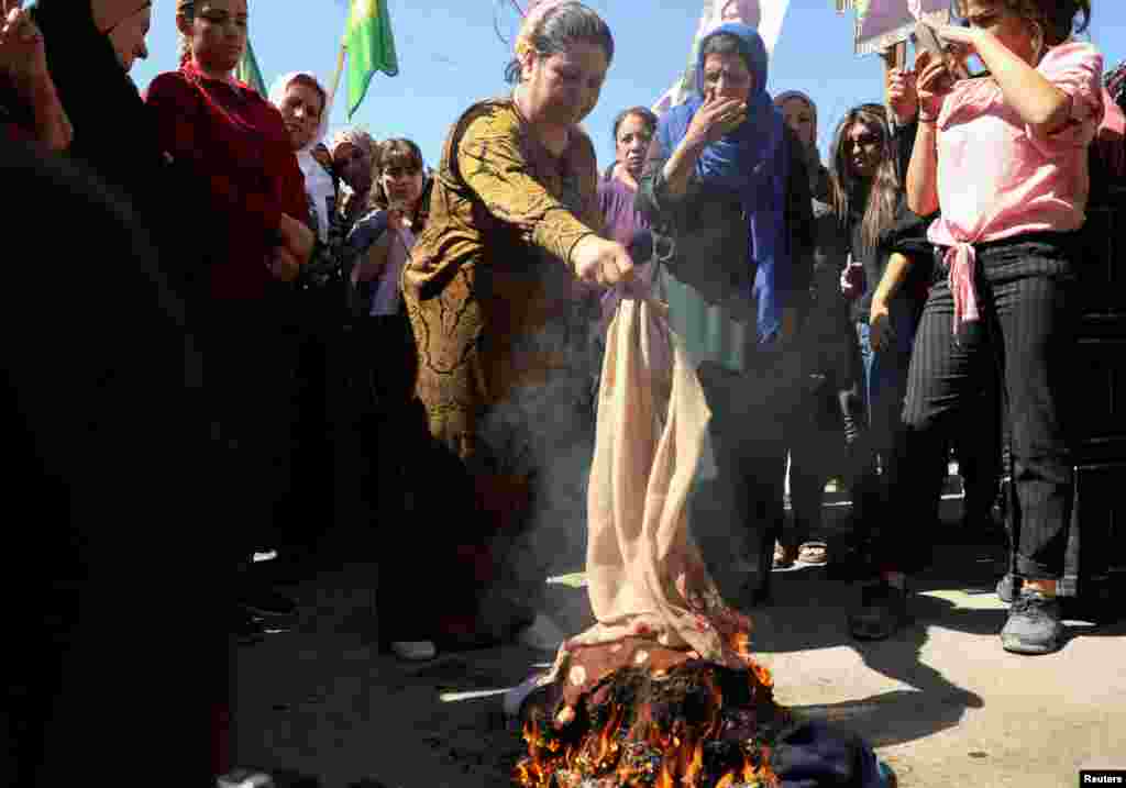 Women burn headscarves during a protest over the death of 22-year-old Kurdish woman Mahsa Amini in Iran, in the Kurdish-controlled city of Qamishli, northeastern Syria. Amini died earlier this month while in the custody of Tehran’s morality police.