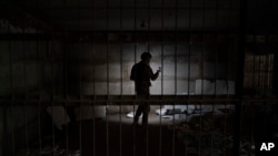 Украинский военный осматривает подвальное помещение, которое, по данным следственных органов Украины, использовалось как камера пыток в период российской оккупации. Казачья Лопань, Харьковская область (архивное фото)
