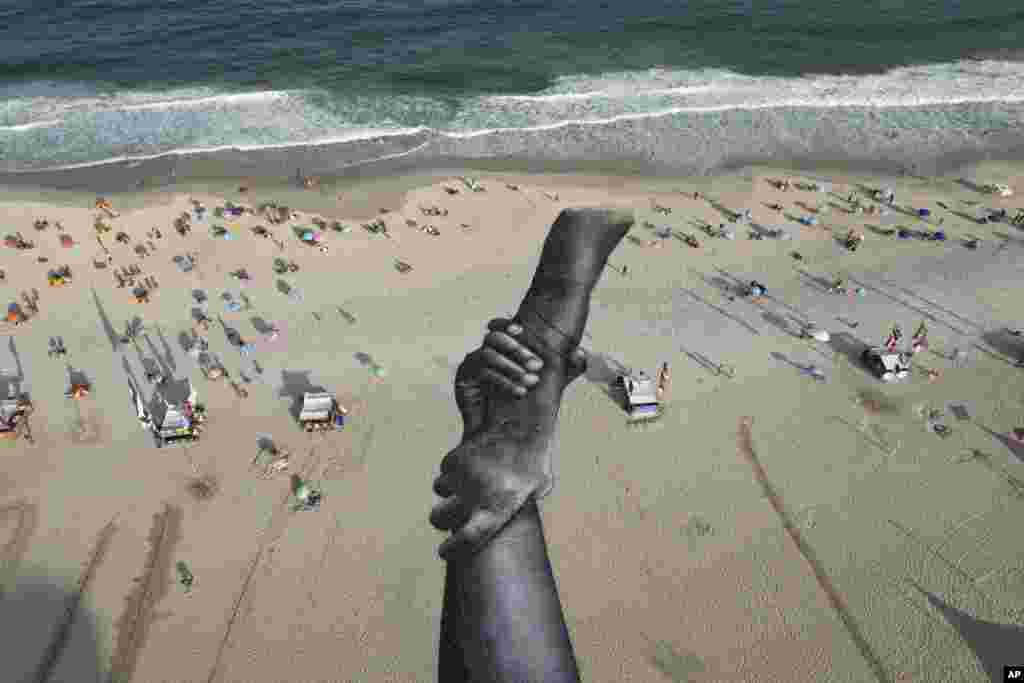 A land-art fresco made with biodegradable paint made of charcoal, chalk, water and milk proteins, by French-Swiss artist Saype, covers Copacabana beach as part of the artist's worldwide project titled "Beyond Walls," in Rio de Janeiro, Brazil.