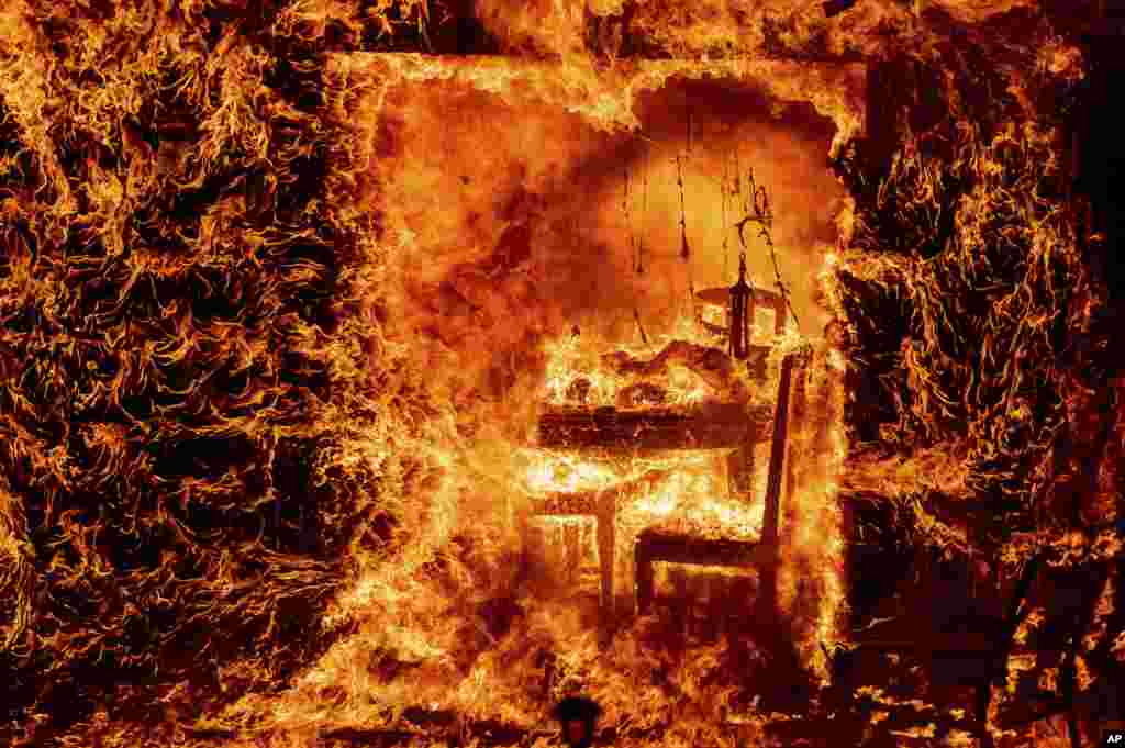Flames engulf a chair inside a burning home as the Oak Fire burns in Mariposa County, California, July 23, 2022.