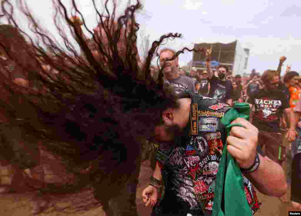 A festivalgoer does a "head banging" during the Wacken Open Air 2022 heavy metal festival in Wacken, Germany.
