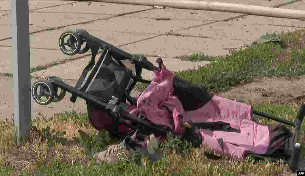A stroller is seen lying on the ground after Russian missiles strike Vinnytsia, in central Ukraine, killing at least 20 people including three children, in this video grab taken from AFPTV footage July 14, 2022, and released July 15, 2022.